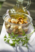 Pickled mushrooms in glass dish, parsley, olive oil