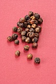 Red peppercorns on pink background
