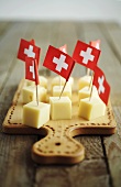 Käsewürfel mit Schweizer Flaggen auf Schneidebrett