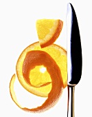 Slice of orange and orange peel with knife