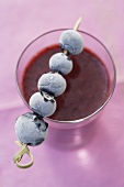 Wild berry smoothie with frozen blueberry skewer