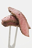 Slices of beef steak on carving fork