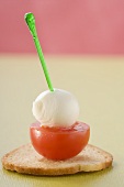 Tomato and mozzarella on cocktail stick on toast