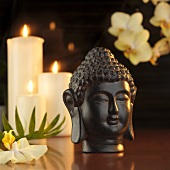 Buddha head in front of candles