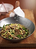 Stir-fried beef, vegetables and noodles in a wok