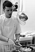Chef frying vegetables in a commercial kitchen