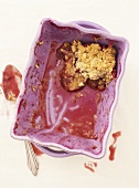 small portion of plum crumble left in baking dish (overhead)