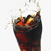 Ice cube falling into a glass of cola