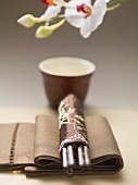 Fabric napkin, chopsticks in silk holder, tea bowl (Asia)