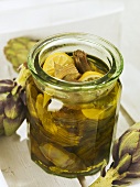 Pickled artichokes with lemon slices in a jar