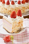 Piece of strawberry cream cake with flaked almonds on server