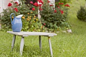 Jug on wooden stool in front of farmhouse