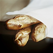 Three baguettes wrapped in paper