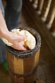 Hand taking butter out of churn