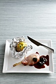 Pork chop with plum sauce and a baked potato