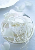 Decorative casket with a string of pearls and white rose petals