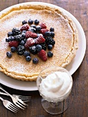 A lemon tart with berries and whipped cream
