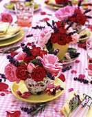 Rosenblüten mit Lavendelblüten in Tassen