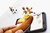 Frankfurter with mustard, note book and footballers