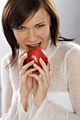 Junge Frau beisst gierig in einen Apfel