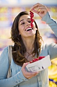 Young woman with redcurrants in a supermarket