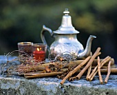 Silver teapot with cinnamon sticks, star anise and candle