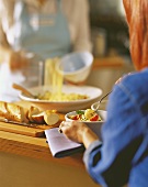 Woman eating spaghetti with tomatoes and basil