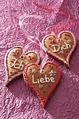 Gingerbread hearts with writing against pink background