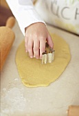 Child's hand cutting out biscuit