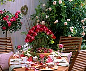Festlich gedeckter Tisch mit Rosen im Freien