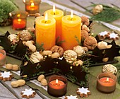 Schale in Sternform mit Nüssen, Zweigen und Kerzen dekoriert