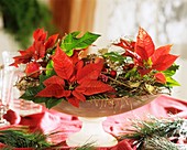 Poinsettias in glass bowl with Christmas decorations