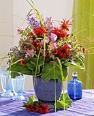 Summer arrangement of flowers and grasses in blue vase