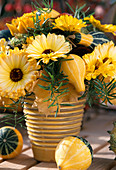 Arrangement of marigolds and ornamental gourds