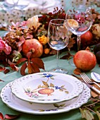 Gedeckter Tisch mit Granatäpfeln dekoriert