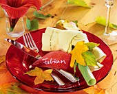 Plate decoration: autumn leaves and yellow napkin
