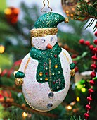 Snowman with hat and scarf hanging on Christmas tree