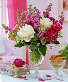 Arrangement of peonies and stocks, bowl of biscuits