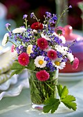 Forget-me-nots and daisies in a glass