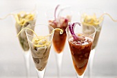 Different kinds of herring salad in cocktail glasses