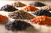 Heaps of different lentils (red, brown, black)