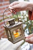 Hand holding lantern with candle