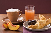 Croissant, jam, nectarine, cappuccino and grapefruit juice