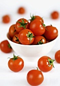 Tomatoes in and beside a bowl