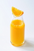 Orange wedge on carafe of orange juice