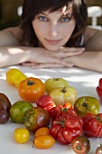 Various kinds of tomatoes, young woman in background