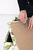 Making an upholstered stool (attaching an upholstery button)