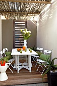 Folding wooden table with chairs on covered terrace