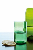 Grünes Glas und grüne Flasche als Vase