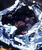 Blackberries in foil on barbecue for barbecue sauce (USA)